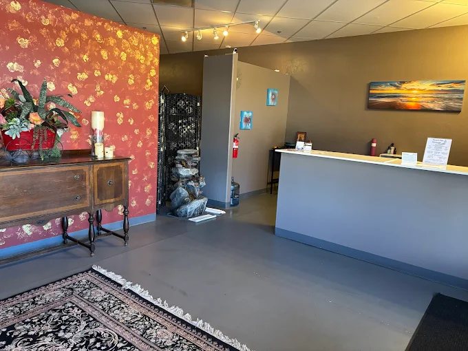 The Zentelle front desk and lobby, with a carved wooden sideboard and fresh flowers by the entrance